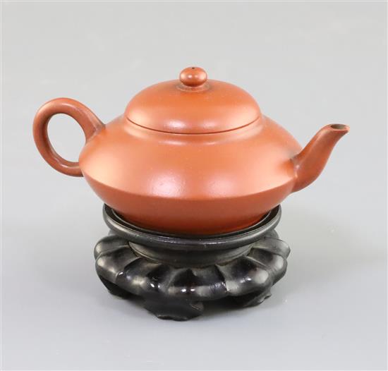 An inscribed Yixing teapot, late 19th/early 20th century, 10.2cm across, wood stand, small chip to spout